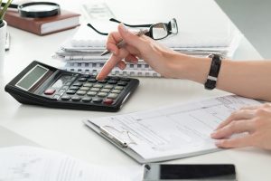 Hand using calculator while doing taxes