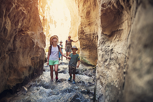 Family hiking through river