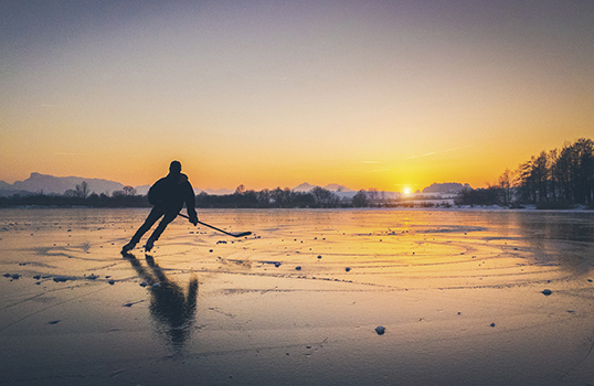 Person playing hockey on a lake in Canada