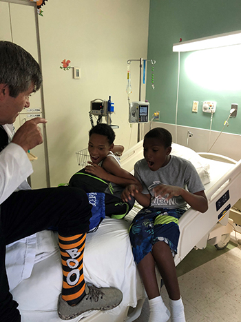 locum tenens pediatrician speaking with two patients sitting on a bed