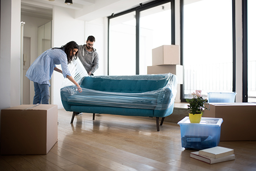 Couple moving sofa out of a room