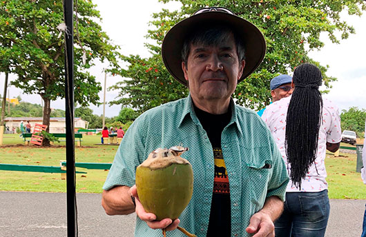 Man holding coconut and wearing a hat - locum tenens pediatrician