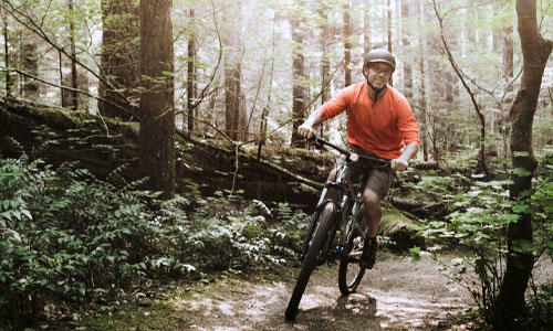 Male physician riding a big on mountain trail in Washington