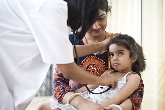 Mother with sick daughter being examined by doctor