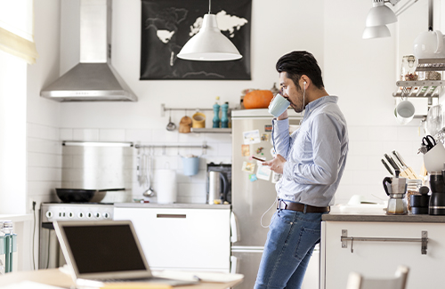 Man in kitchen with earbuds