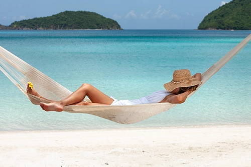Picture of a woman sleeping in hammock on a beach in the USVI